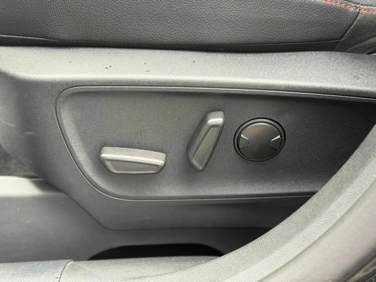 Gros plan sur les commandes de réglage électrique du siège conducteur du Ford Kuga noir Agathe 2023, finition ST-Line X.