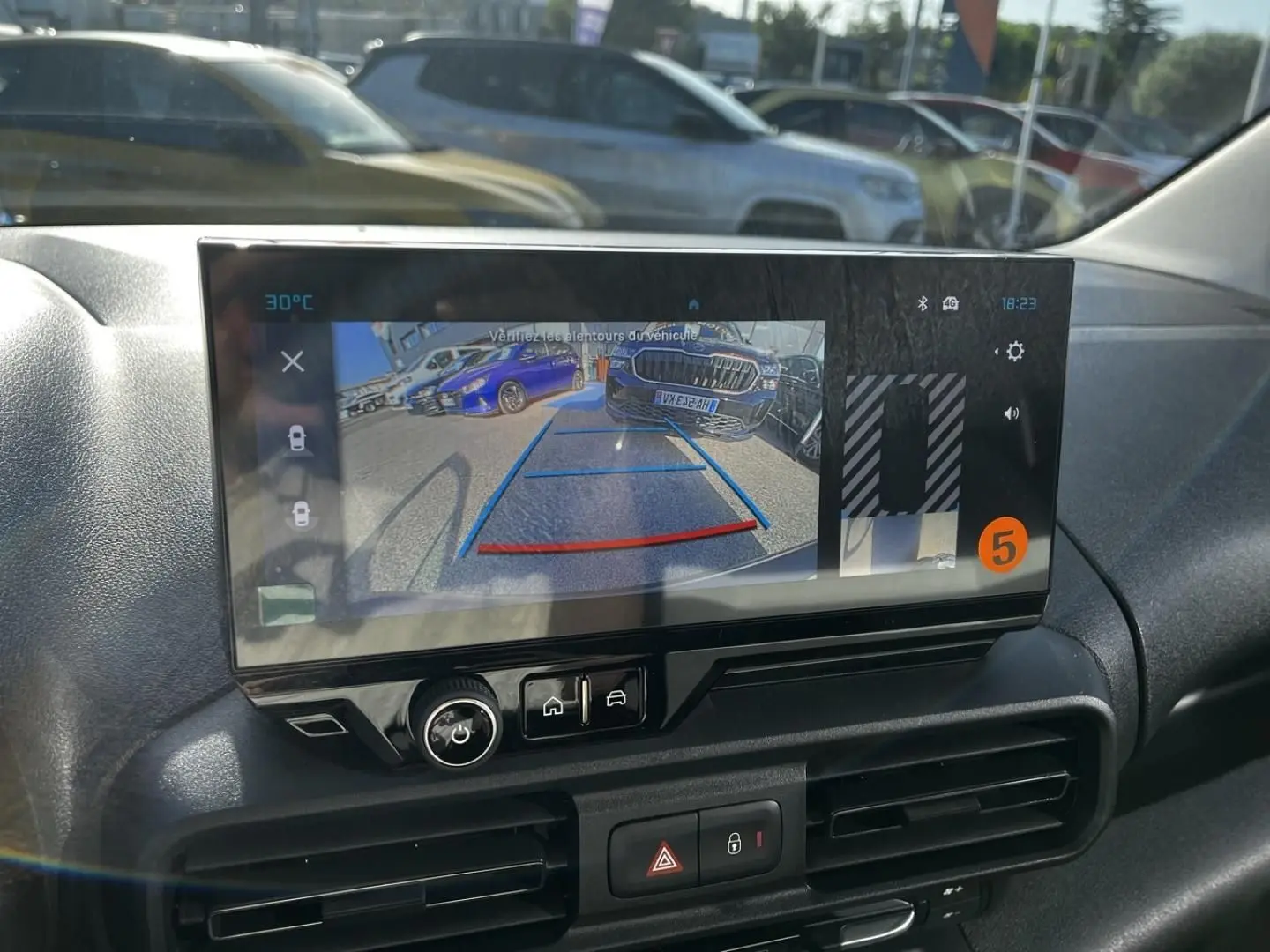 Écran intérieur du Citroën Berlingo noir, vue de la caméra de recul avec lignes de guidage colorées.