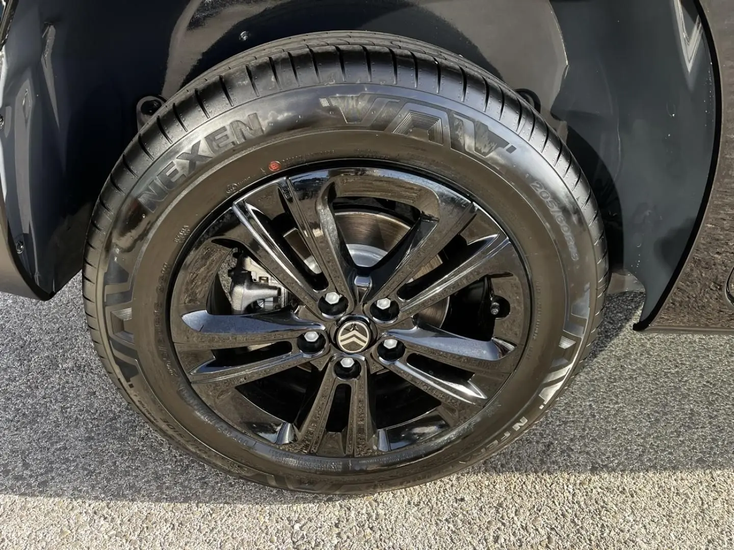Gros plan sur la roue avant droite noire perla nera metal du Citroën Berlingo 2026 avec jante alliage noire brillante.