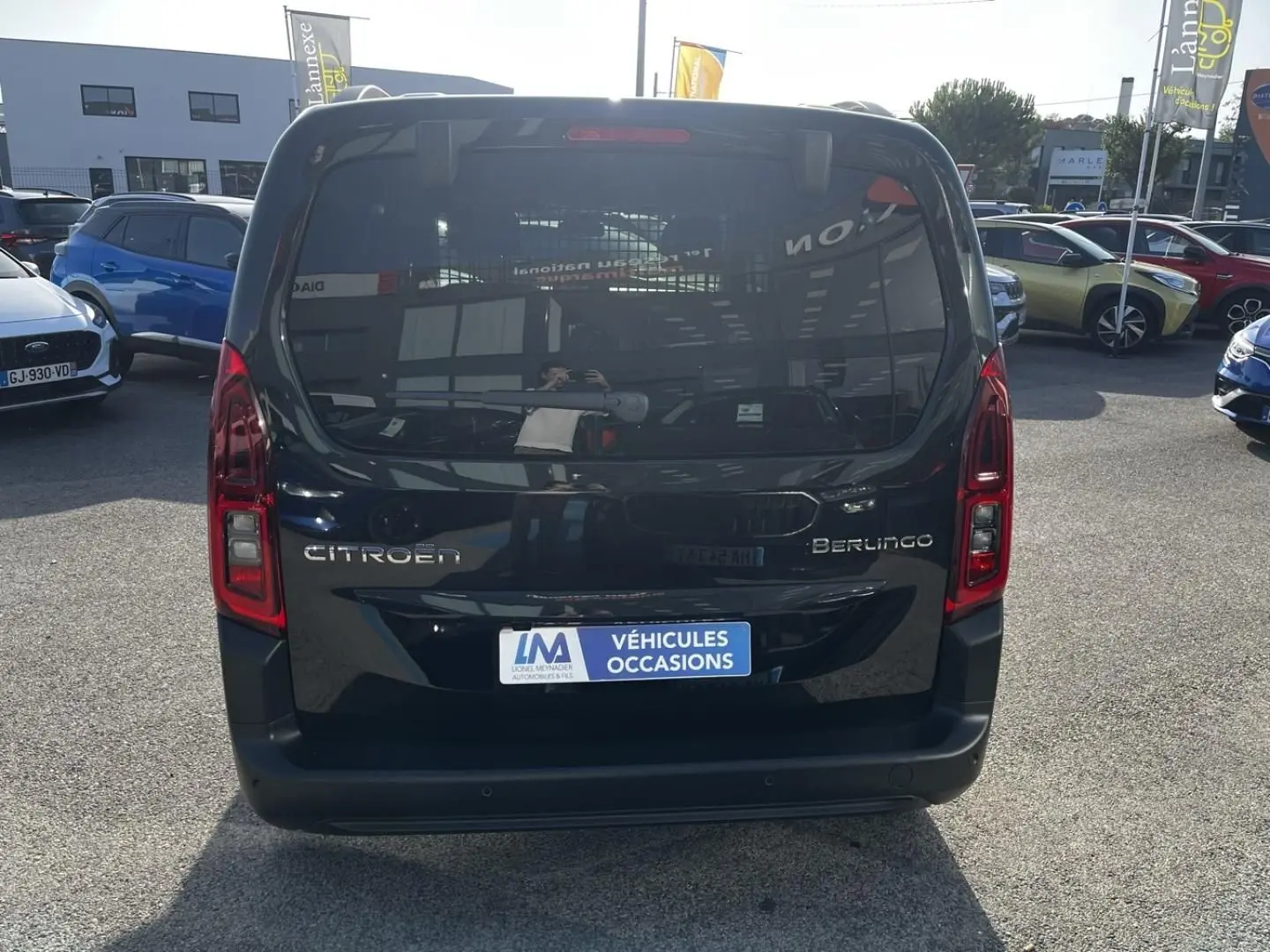 Vue arrière d'un Citroën Berlingo noir Perla Nera métallisé 2026, avec feux verticaux et plaque "Véhicules Occasions".