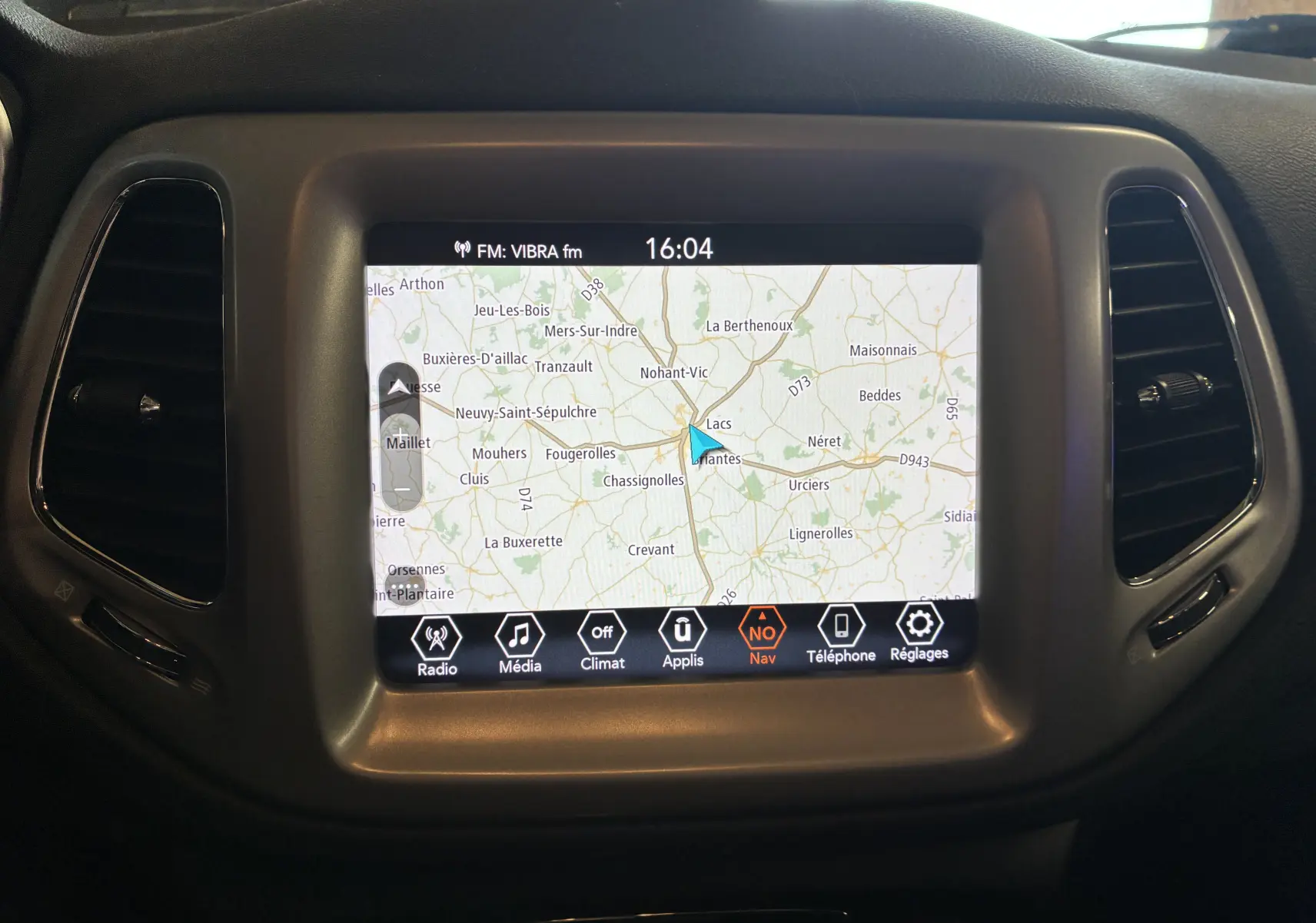 Écran tactile central du tableau de bord du Jeep Compass ivoire, affichant la navigation GPS en mode carte.