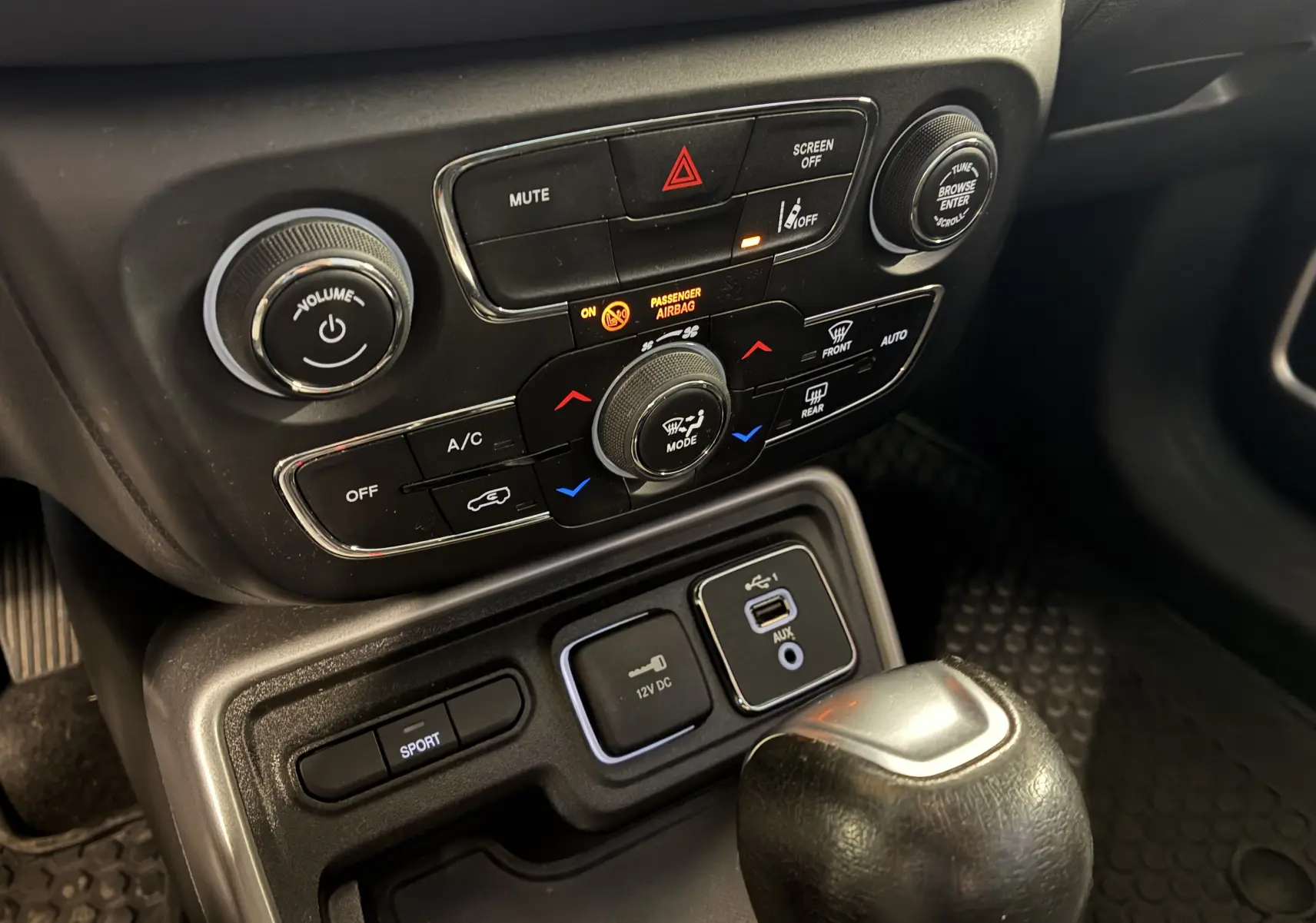 Gros plan sur la console centrale noire du Jeep Compass Longitude 2021 avec commandes climatisation et bouton sport.