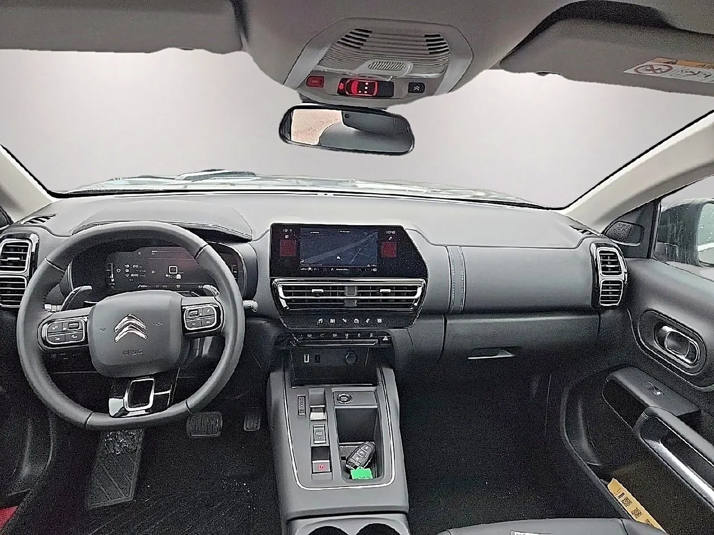 Vue intérieure avant du tableau de bord et volant cuir multifonction du Citroën C5 Aircross gris 2025 avec écran tactile central.