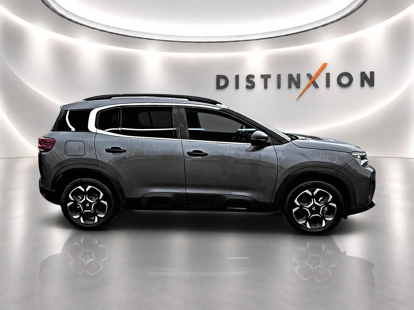 Vue de profil droit du Citroën C5 Aircross gris 2025 avec jantes alu et barres de toit noires.
