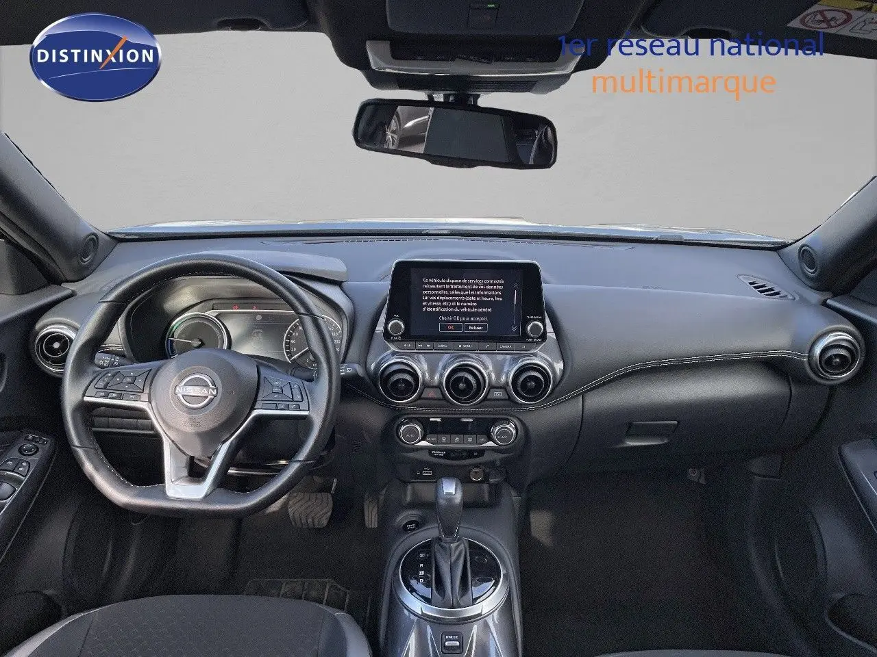 Intérieur noir du Nissan Juke 2024, vue frontale du tableau de bord avec écran tactile et volant multifonction.