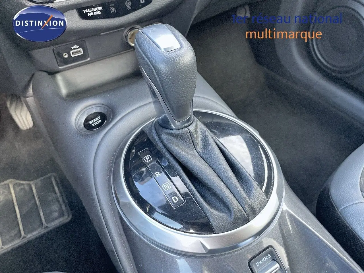 Le levier de vitesses automatique en cuir noir du Nissan Juke 2024, avec bouton start/stop et mode D visible.