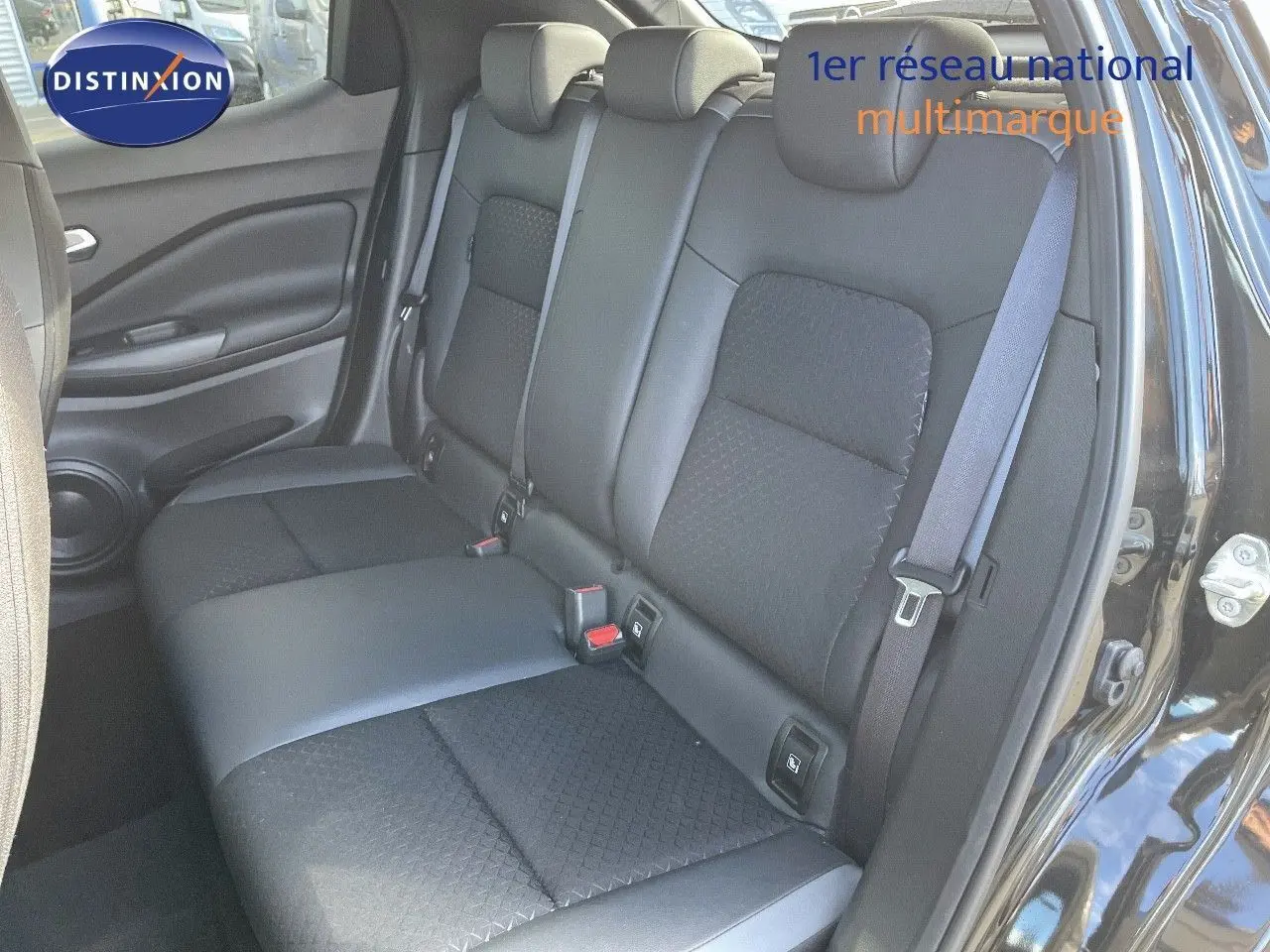 Vue intérieure sur les sièges arrière en cuir gris et tissu noir du Nissan Juke 2024, porte arrière droite ouverte.