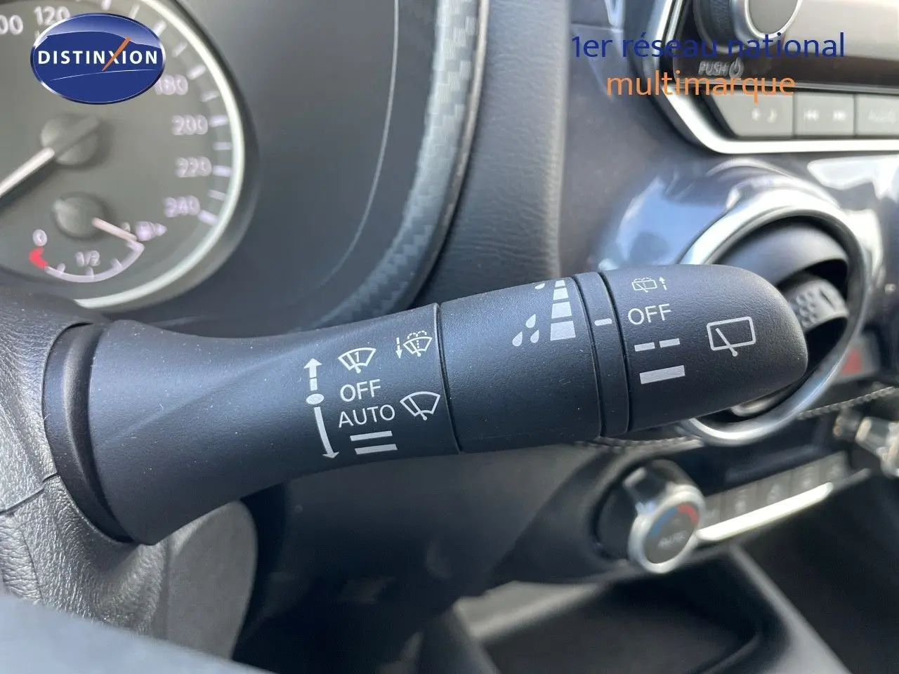 Gros plan sur la commande d'essuie-glace du Nissan Juke 2024, intérieur noir avec détails de tableau de bord visibles.