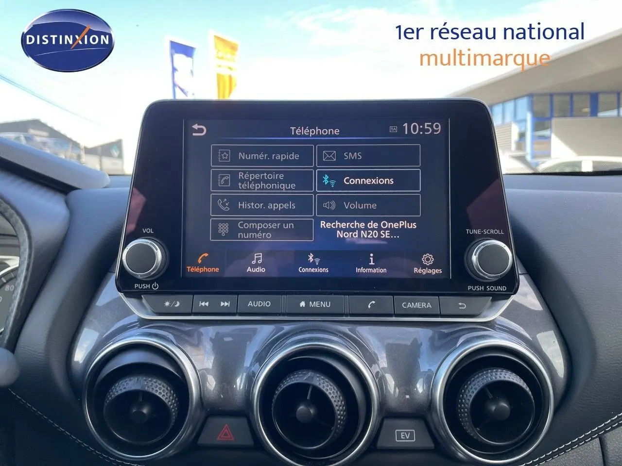 Écran tactile central du Nissan Juke 2024 affichant le menu téléphone, avec aérateurs ronds argentés en dessous.