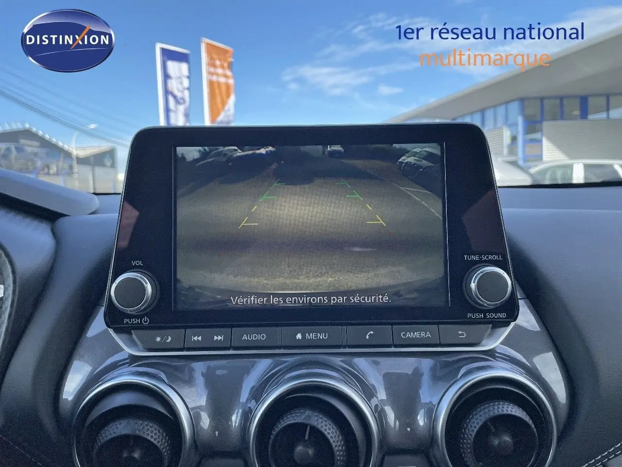 Écran central du Nissan Juke 2024 montrant la caméra de recul avec les commandes audio et climatisation en dessous.
