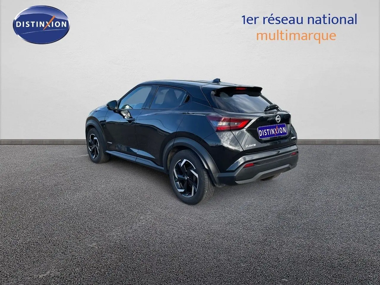 Nissan Juke noir métal vu en 3/4 arrière côté gauche, soulignant ses lignes modernes et ses jantes noires.