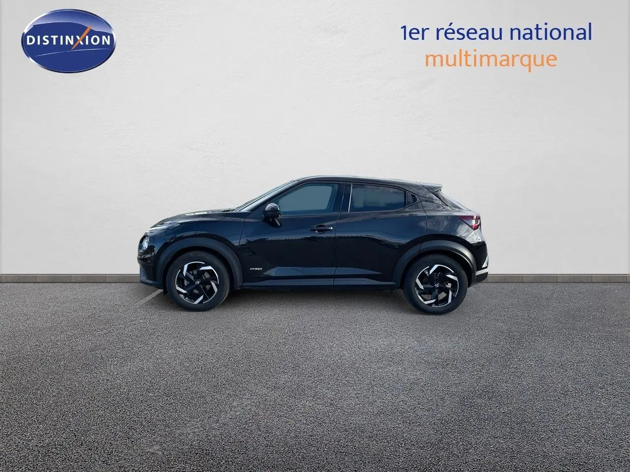 Profil côté gauche du Nissan Juke 2024 noir métal hybride, soulignant ses jantes bi-ton et lignes compactes.