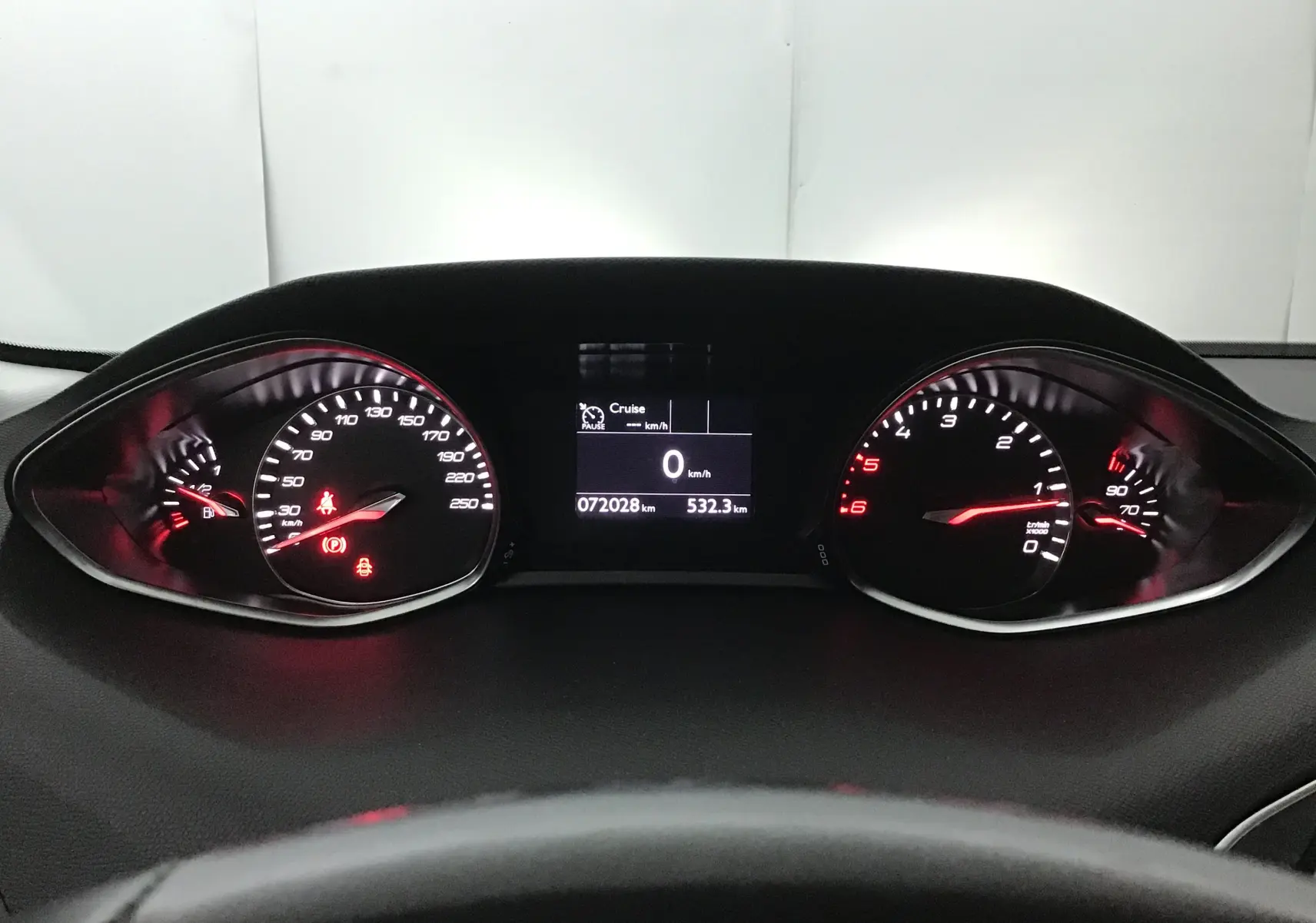 Vue rapprochée du tableau de bord du Peugeot 308 SW blanc 2018, affichant le compteur et l'écran central.