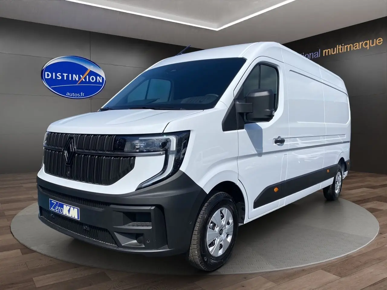 Renault Master blanc en 3/4 avant droit, avec calandre noire et jantes argentées, sur fond intérieur showroom.