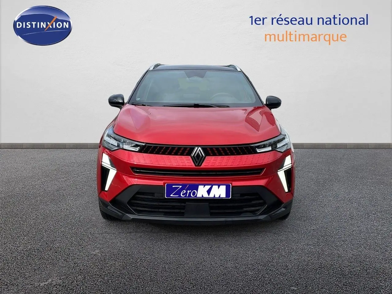 Vue frontale d'un Renault Captur E-Tech hybride rouge passion avec toit noir et feux LED allumés.