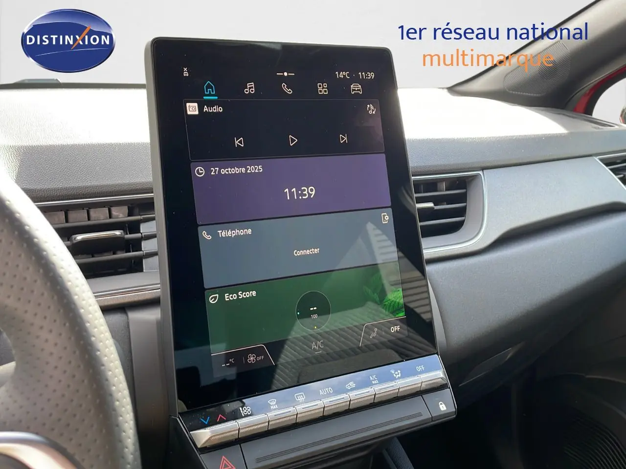 Écran tactile central en gros plan dans l’habitacle du Renault Captur E-Tech hybride 2025, volant partiel visible.