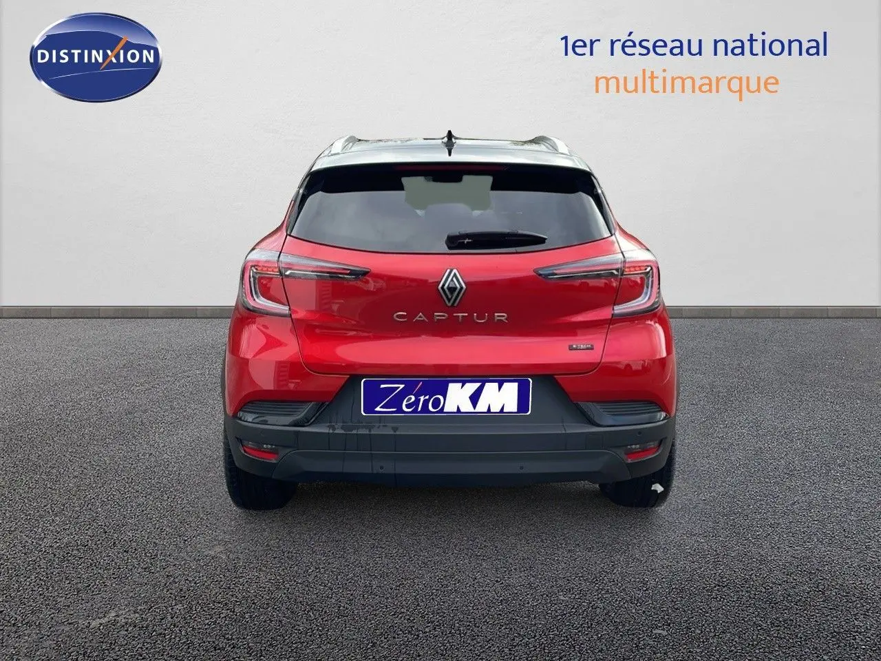 Vue arrière d'un Renault Captur rouge passion avec toit noir, version E-Tech hybride 2025, sur fond neutre.