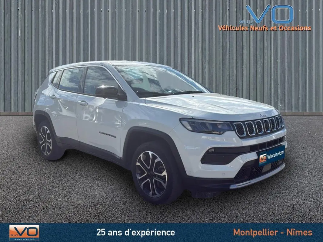Jeep Compass blanc en 3/4 avant droit, avec jantes alliage 18 pouces et calandre distinctive à sept fentes.