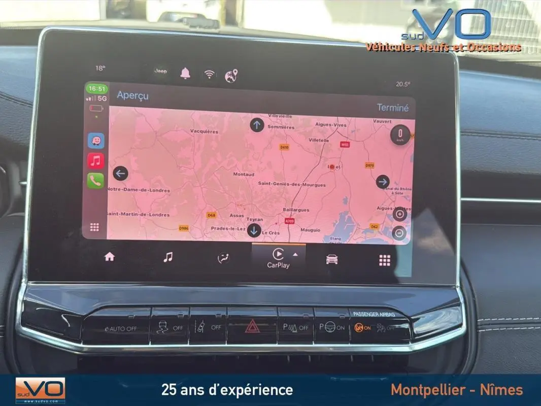 Écran tactile central du Jeep Compass 2024 affichant la navigation, avec commandes et tableau de bord noir visible.