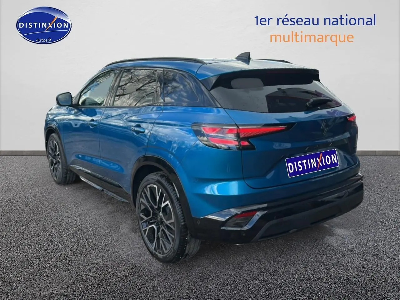 Vue 3/4 arrière droite d’un Renault Austral bleu avec jantes alliage noires et vitres teintées.