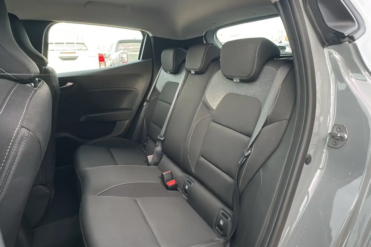 Vue intérieure côté droit sur la banquette arrière gris foncé de la Renault Clio Gris Rafale 2025, avec ceintures et appuie-têtes.