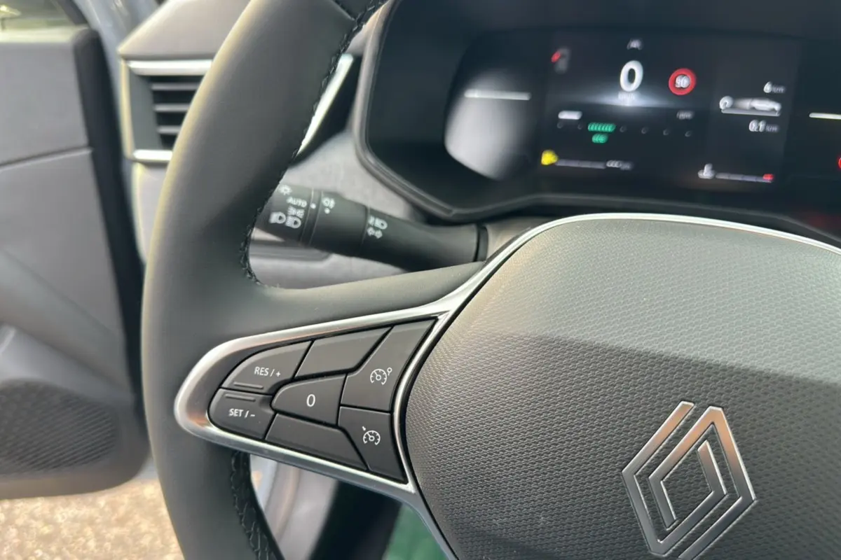 Gros plan sur le volant cuir multifonctions de la Renault Clio DCI 100 Evolution Camera avec commandes intégrées.