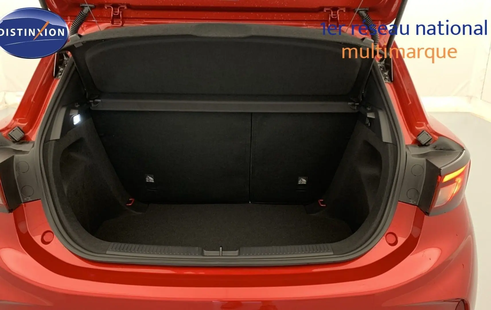 Coffre ouvert vu de l'arrière d'une MG3 1.5 Hybrid+ 195 Luxury rouge Diamond, intérieur noir spacieux et éclairé.