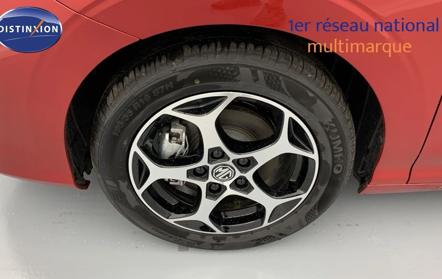 Gros plan sur la roue avant gauche de la MG3 1.5 Hybrid+ 195 Luxury en rouge Diamond avec jante alliage bicolore.