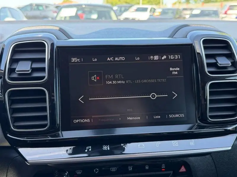 Vue rapprochée de l’écran central tactile du tableau de bord du Citroën C5 Aircross gris, affichant la radio FM RTL.