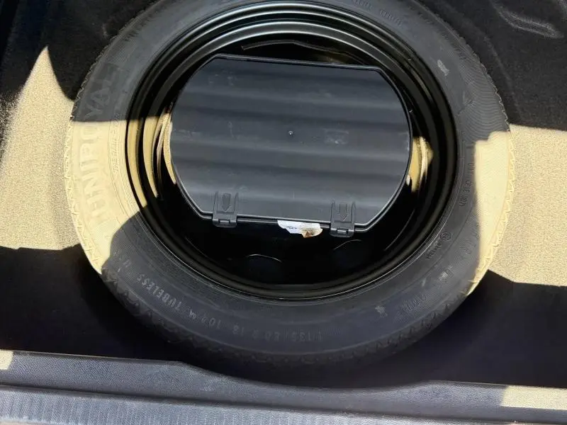 Vue rapprochée de la roue de secours noire dans le coffre d'une Citroën C5 Aircross gris 2020.