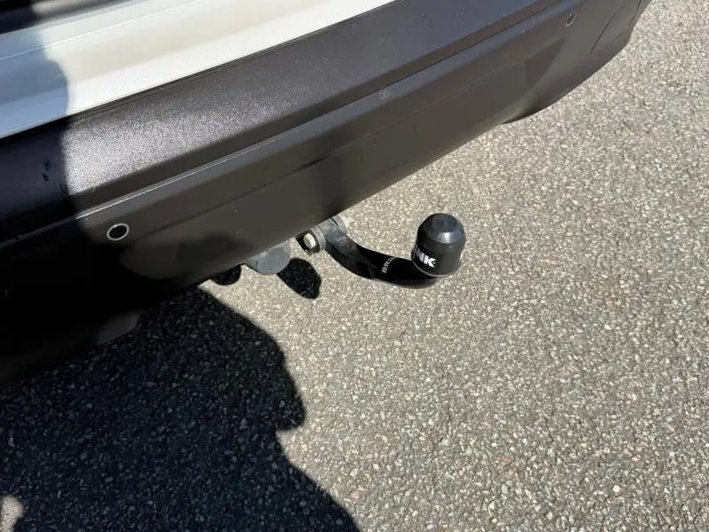 Gros plan sur l'attelage arrière noir d'un Citroën C5 Aircross gris, avec capteur de stationnement visible.