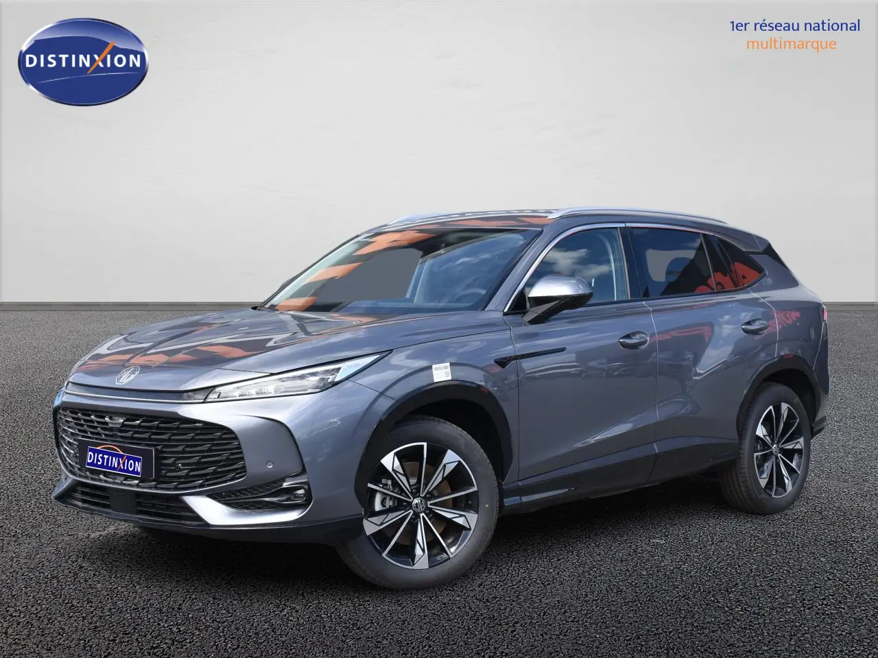 MG Motor EHS gris en 3/4 avant droit, avec jantes alliage 19 pouces et calandre noire distinctive.
