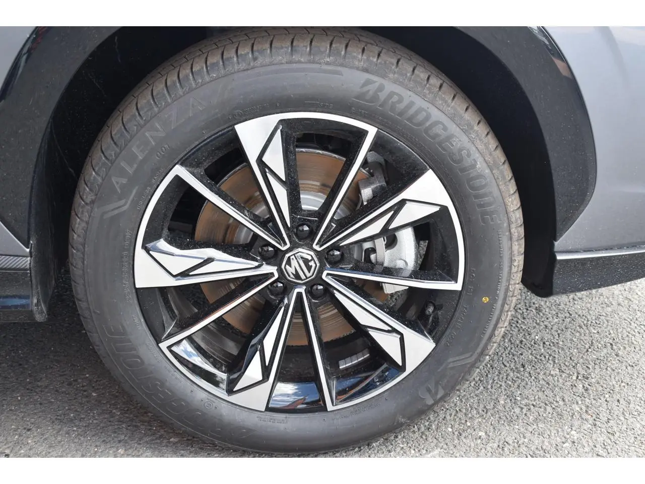 Gros plan sur la jante alliage 19 pouces bicolore noire et argent du MG MOTOR EHS gris, roue avant droite.