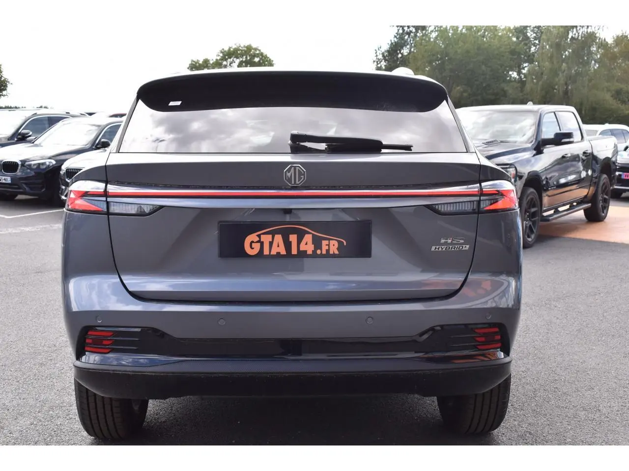 Vue arrière d'un MG MOTOR EHS gris 2026 avec feux LED continus et logo MG centré sur le hayon.