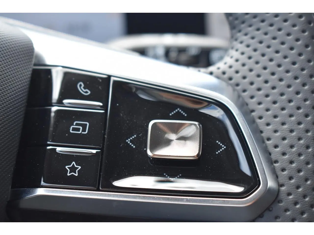 Gros plan sur les commandes multifonctions du volant perforé du MG Motor EHS gris, version hybride 2026.