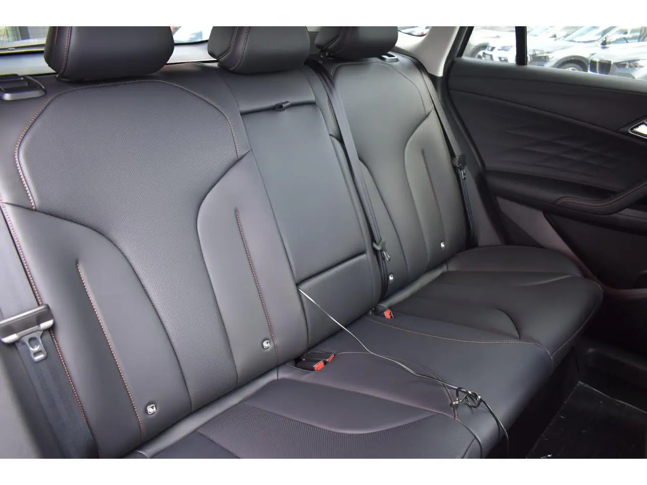Vue intérieure sur la banquette arrière en cuir noir avec surpiqûres orange du MG Motor EHS 1.5 Hybrid+ 224 ch Luxury 2026.