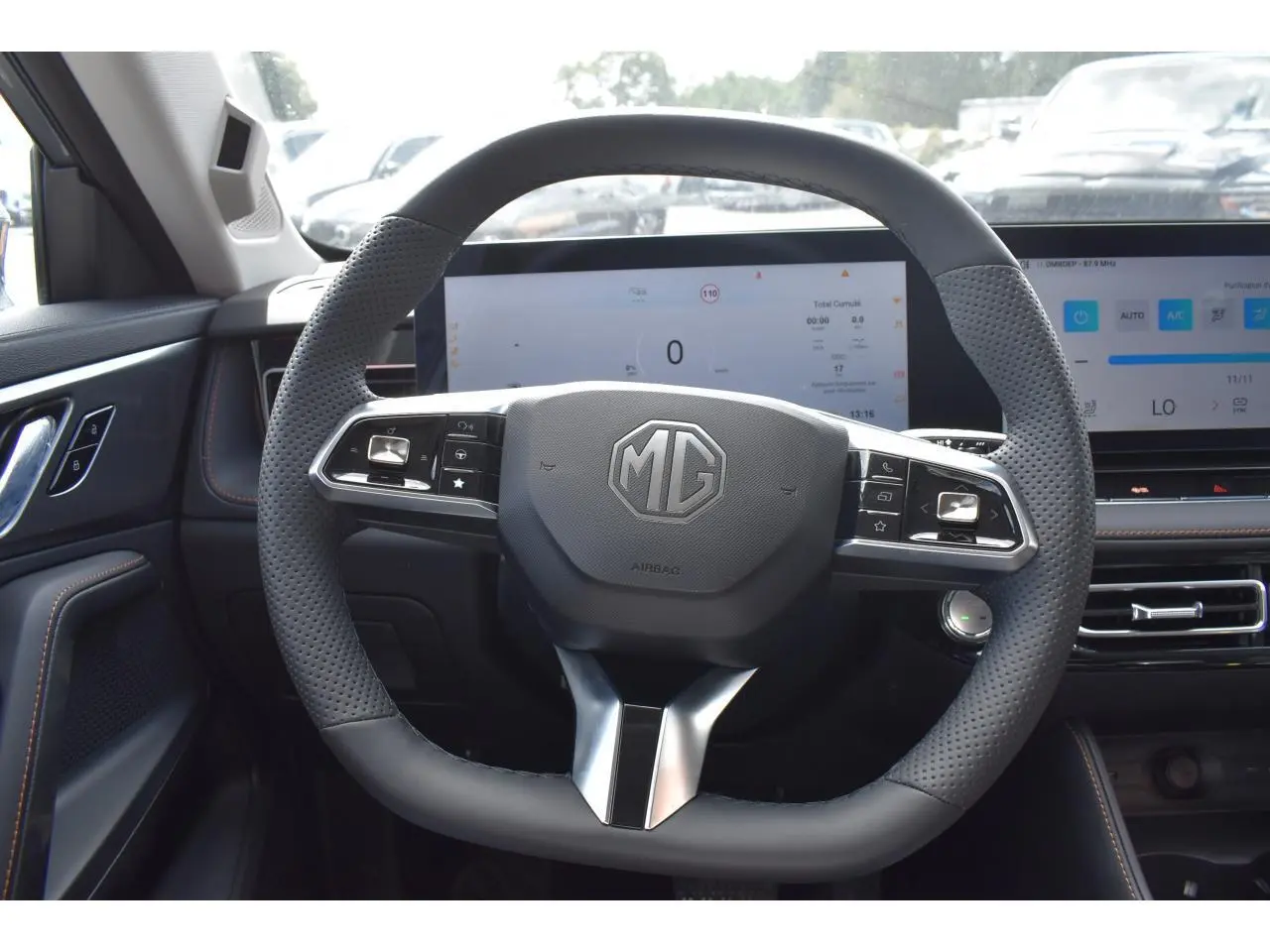 Vue intérieure centrée sur le volant perforé du MG Motor EHS 1.5 Hybrid+ 224 ch, avec tableau de bord numérique.