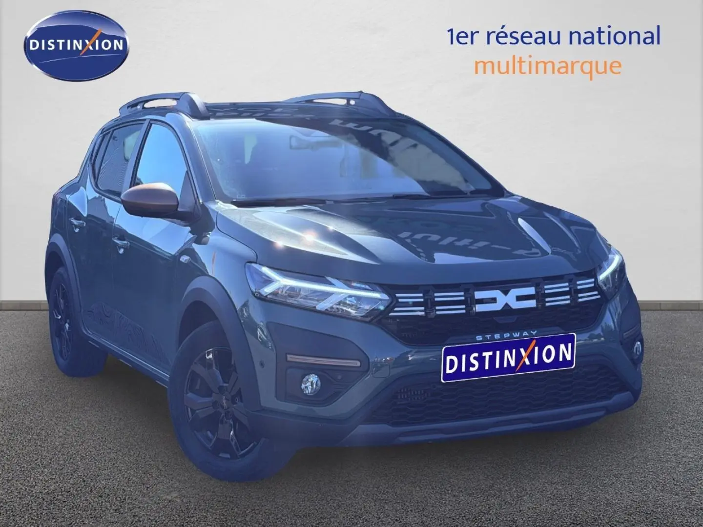 Vue 3/4 avant d'une Dacia Sandero Stepway 2025 en kaki lichen avec jantes noires et barres de toit.