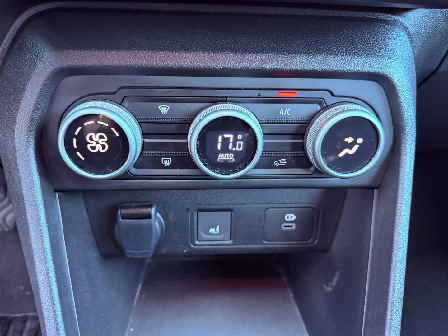 Gros plan sur la commande de climatisation automatique de la Dacia Sandero 2025, finition kaki lichen.