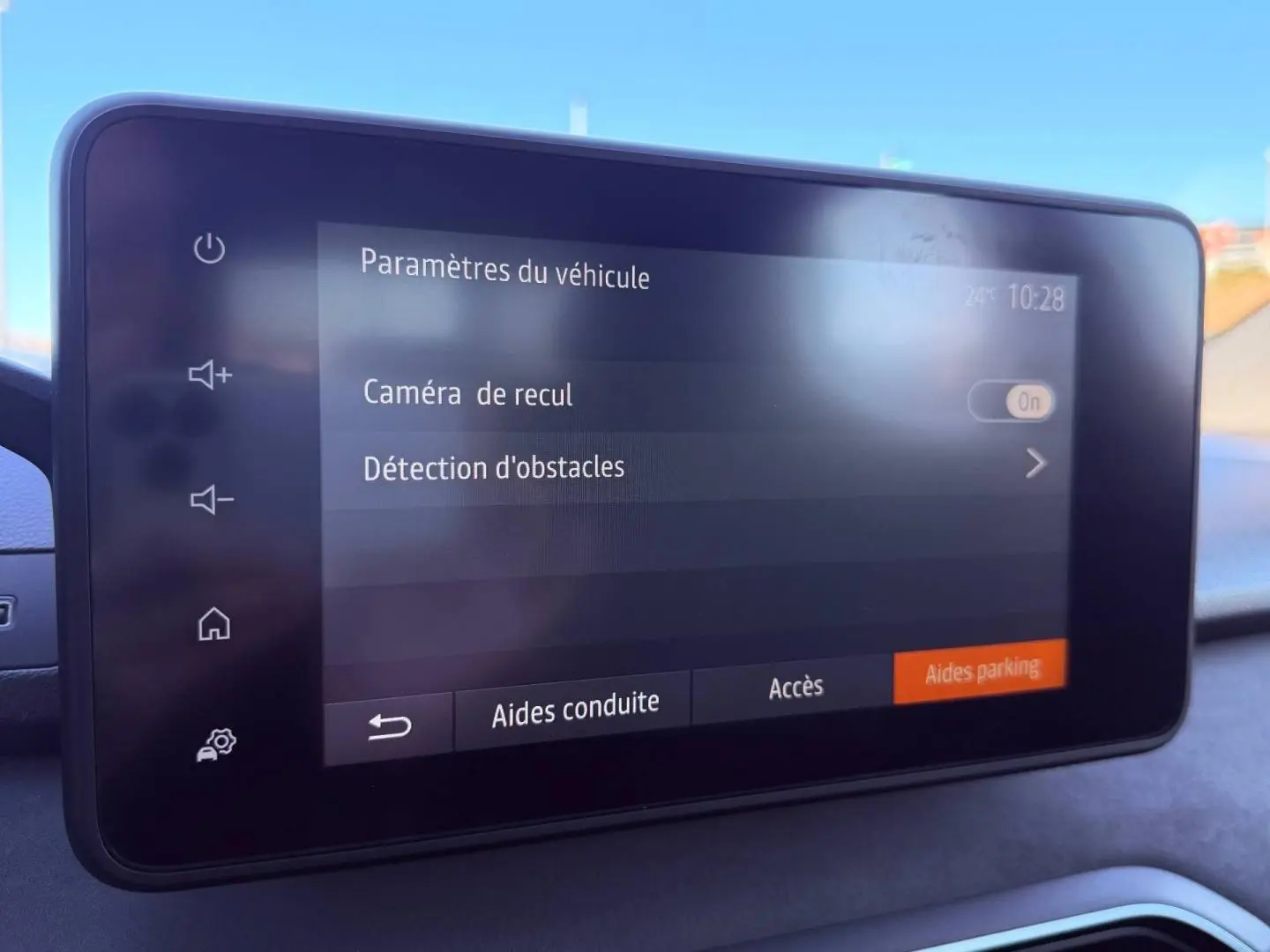Écran tactile du tableau de bord de la Dacia Sandero 2025 affichant les paramètres de caméra de recul et détection d'obstacles.