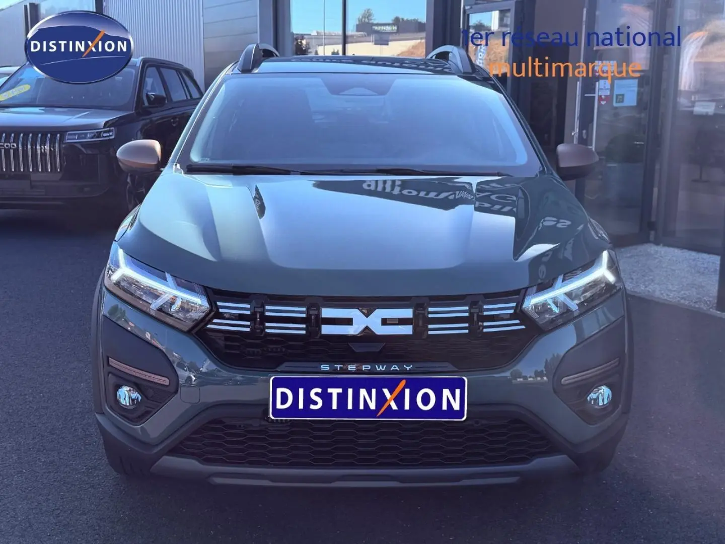 Vue frontale d'une Dacia Sandero Stepway 2025 en kaki lichen avec phares LED et calandre noire distinctive.