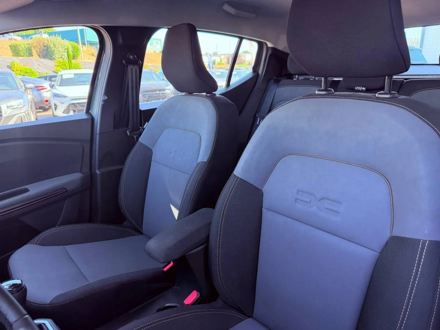 Vue intérieure côté avant droit des sièges tissu brun cuivré avec logo Extreme embossé sur une Dacia Sandero 2025.