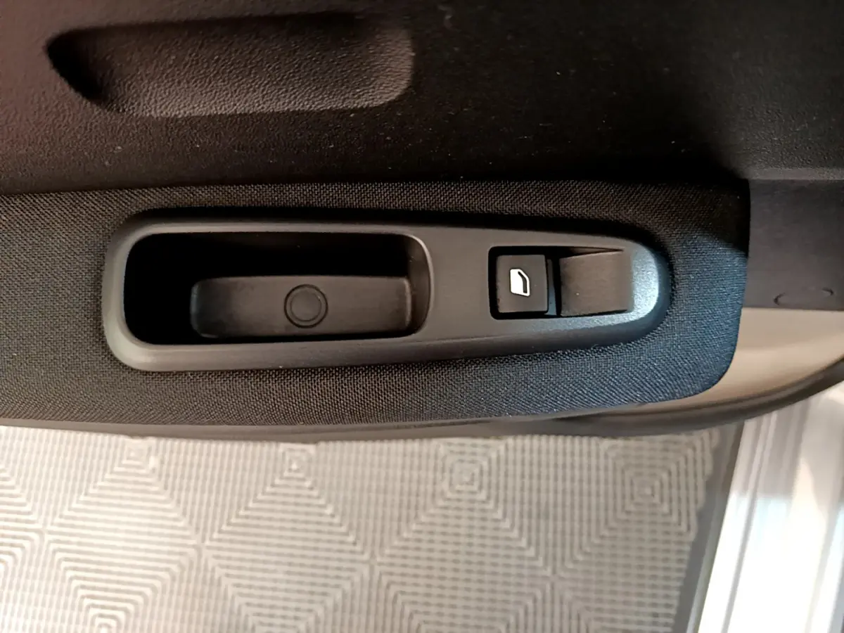 Poignée intérieure noire avec bouton de verrouillage sur la porte côté gauche d'une Citroën C3 gris clair 2019.