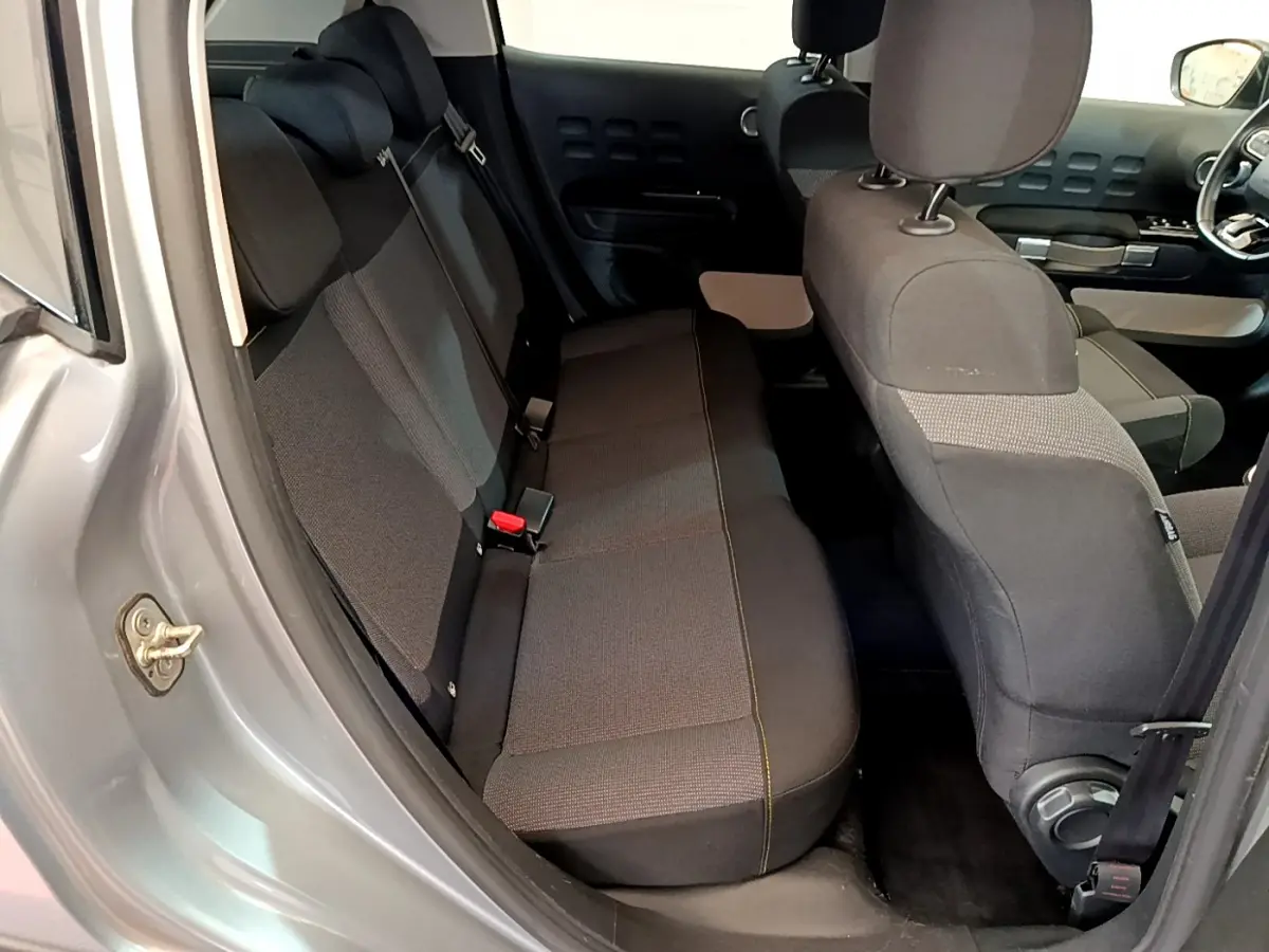 Vue intérieure côté gauche sur la banquette arrière et sièges avant d'une Citroën C3 gris clair de 2019.