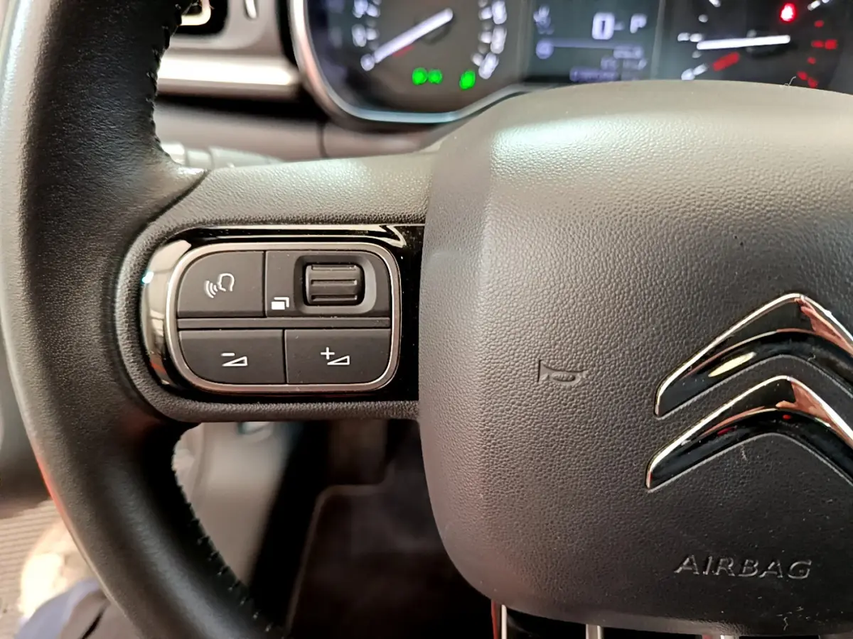 Gros plan sur le volant cuir noir de la Citroën C3 2019 avec commandes audio intégrées côté gauche.