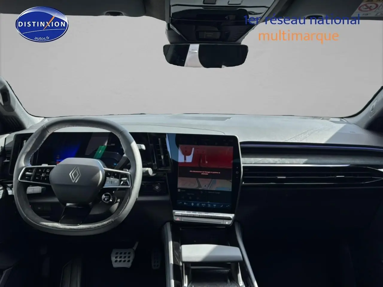Vue intérieure frontale du tableau de bord noir du Renault Austral 2026 avec écran tactile vertical et volant multifonction.