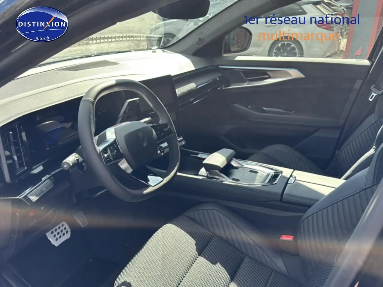 Vue intérieure côté conducteur du Renault Austral noir 2026, volant multifonction et sièges en Alcantara avec surpiqûres bleues.