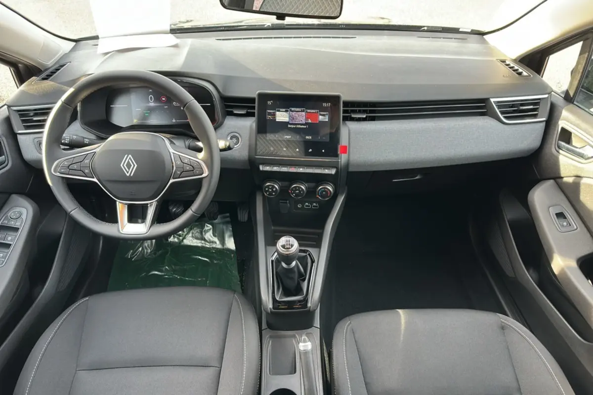 Vue intérieure avant de la Renault Clio DCI 100 Evolution avec tableau de bord noir et écran tactile central.