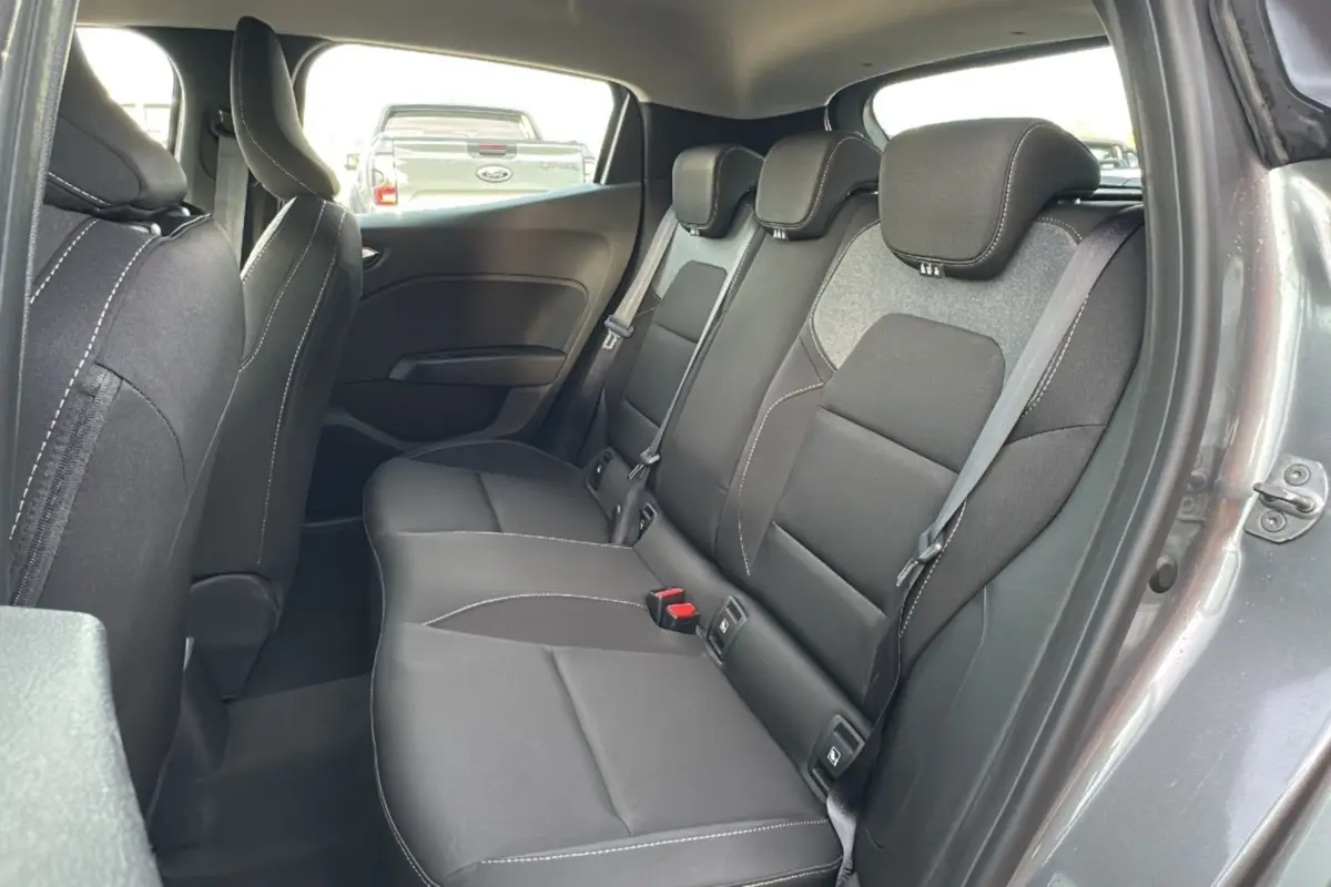 Vue intérieure de la banquette arrière noire avec appuie-têtes et ceintures dans une Renault Clio gris schiste 2025.