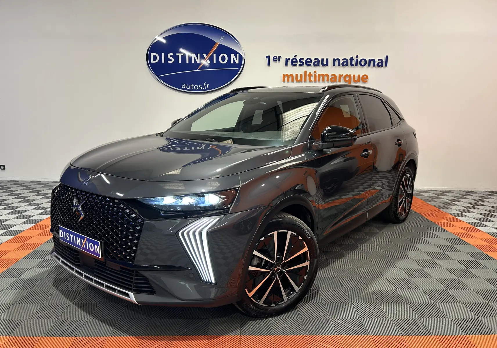 Vue 3/4 avant d’un DS7 gris titane avec signature lumineuse LED distinctive et jantes bi-ton en concession.